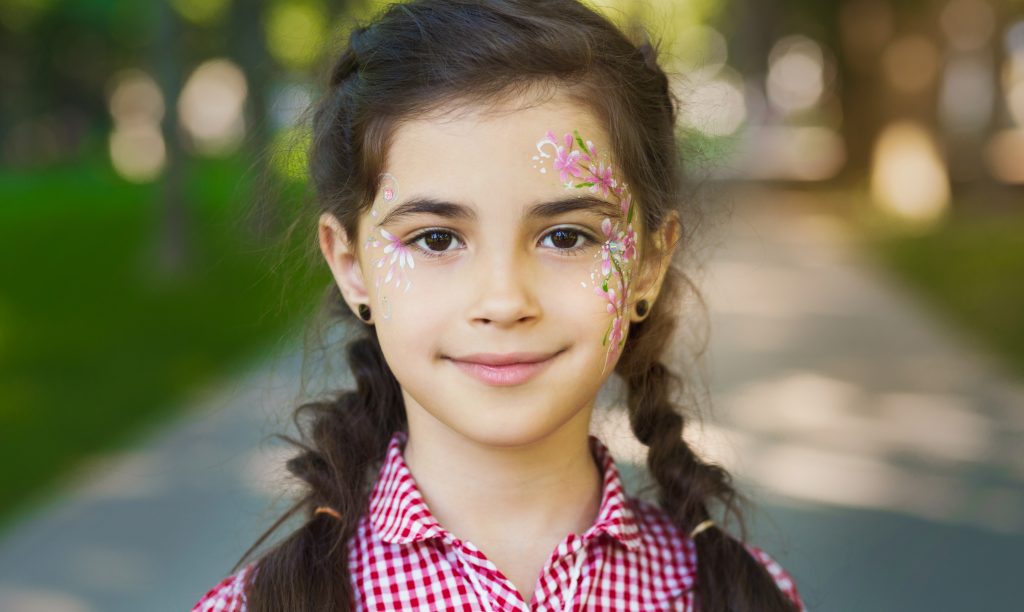 A pretty little girl with shining eyes and a painted face