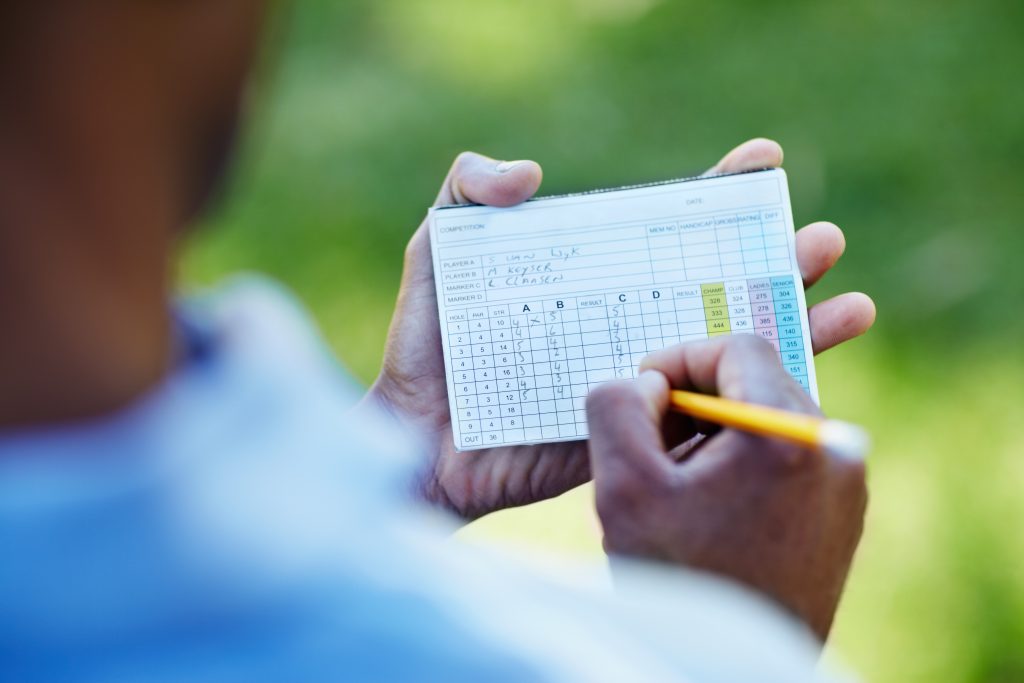 Person marking a golf scorecard—metaphor for keeping score of AGI progress