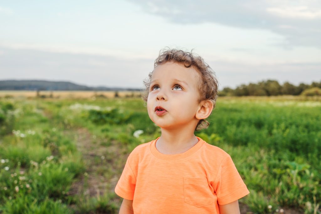 A young boy looks to the sky, quietly awed by its breathtaking beauty.