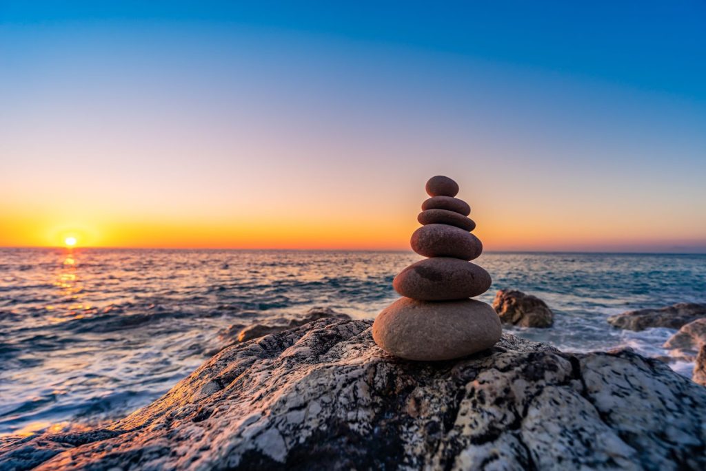 Stacked stones on a beach at sunset