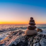 Stacked stones on a beach at sunset